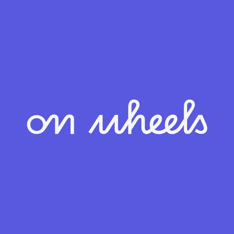 Logo principal On Wheels blanc sur fond violet.
